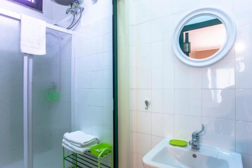 La salle de bains est pourvue d'une douche, d'un lavabo et d'un miroir. dans l'établissement Loft Marini, à Villa San Pietro