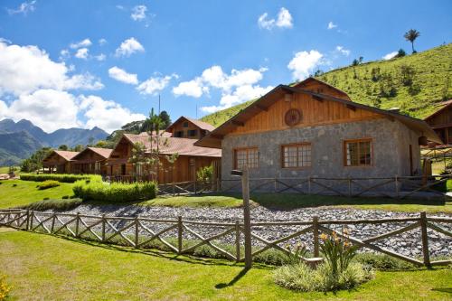 a house in the mountains with a fence at Fazenda Suica Le Canton in Teresópolis