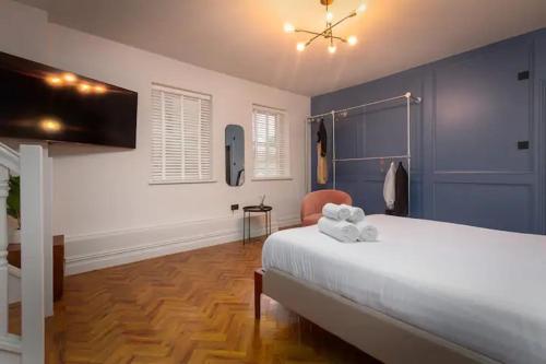 - une chambre avec un lit blanc et des murs bleus dans l'établissement Capri Stays - Apartment One, à Blackpool
