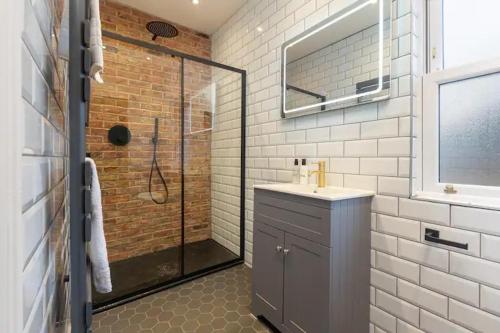 a bathroom with a walk in shower and a sink and a mirror at Capri Stays - Apartment One in Blackpool