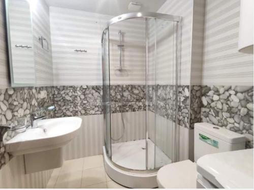 a bathroom with a shower and a toilet and a sink at Apartment in Orbi Sea Tower in Batumi