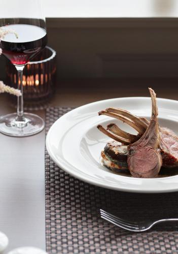 a plate with a piece of meat and a glass of wine at Teach de Broc in Ballybunion