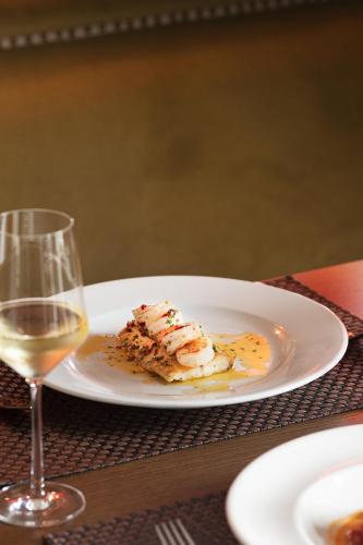a plate with a piece of food and a glass of wine at Teach de Broc in Ballybunion