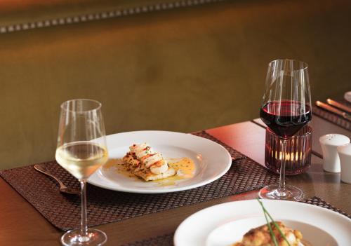 巴利布尼恩的住宿－提德布羅克酒店，一张桌子,上面放着两盘食物和两杯葡萄酒