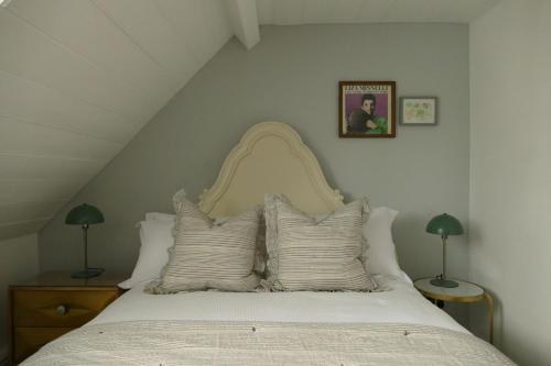1 dormitorio con 1 cama con sábanas y almohadas blancas en DINCKLEY COURT Boutique Riverside Rooms en Abingdon