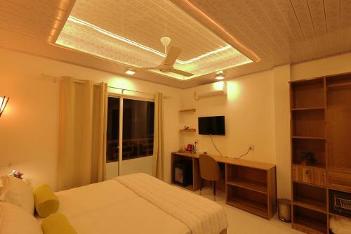 1 dormitorio con 1 cama y ventilador de techo en Batuta Maldives Fourson en Thulusdhoo