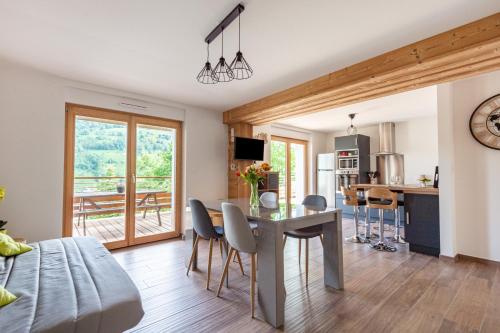 une cuisine et une salle à manger avec une table et des chaises dans l'établissement Le Planois, à La Bresse