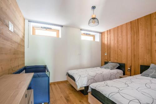 1 Schlafzimmer mit 2 Betten, einem Schreibtisch und 2 Fenstern in der Unterkunft Le Planois in La Bresse