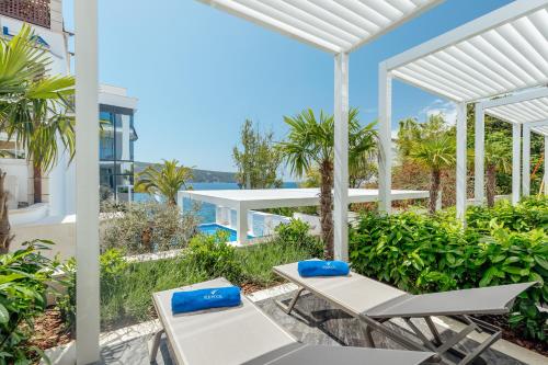 a patio with chairs and a view of the water at Hotel Perla in Herceg-Novi