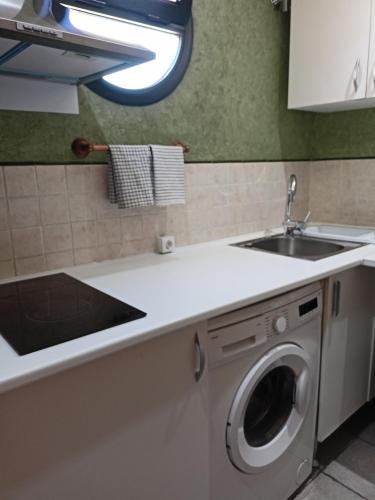 a kitchen with a washing machine and a sink at SERVILUx 2 in Torremolinos