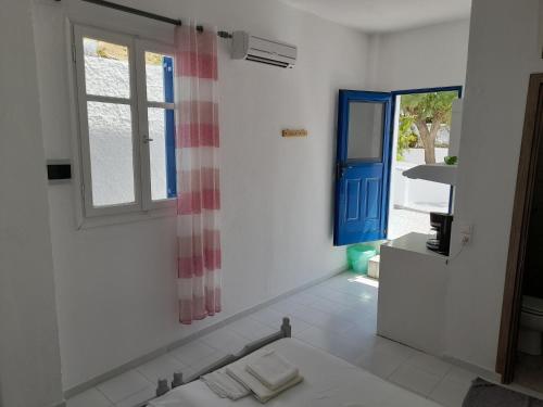 a white room with a blue door and a window at Silver view in Batsi