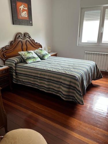 1 dormitorio con 1 cama grande y cabecero de madera en Punta Caldebarcos, en San Mamede de Carnota