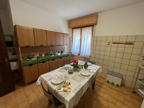 eine Küche mit einem Tisch mit Tellern und Blumen darauf in der Unterkunft Secret Garden Egle in Caprino Veronese