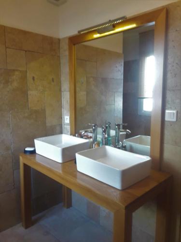 une salle de bain avec deux lavabos blancs et un miroir dans l'établissement maison grysélienne, à Gréoux-les-Bains