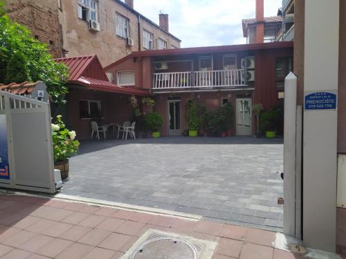 einen leeren Innenhof mit einem Haus mit Balkon in der Unterkunft Apartments Imper - IMD in Niš