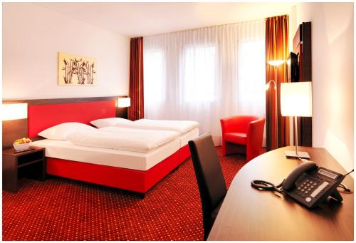 a hotel room with a bed and a telephone at Best Western Plus Amedia Wien in Vienna