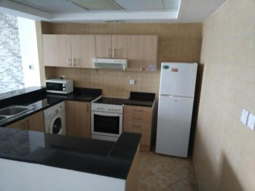 a kitchen with a white refrigerator and a sink at 1 BHK - Concorde Tower - JLT Cluster H in Dubai