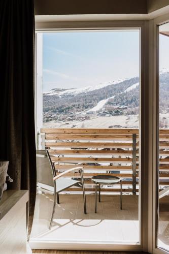 a view from a room with a table and chairs at Hotel Lac Salin Spa & Mountain Resort in Livigno