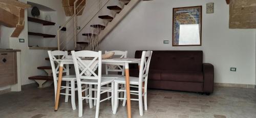 a table and chairs in a living room with a couch at Casa vacanze salento Vicosoluna in Morciano di Leuca