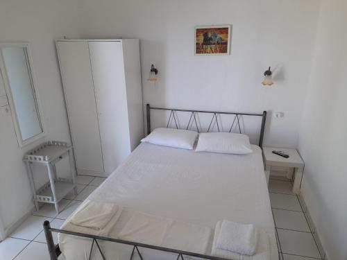 a bedroom with a bed with white sheets at Silver view in Batsi