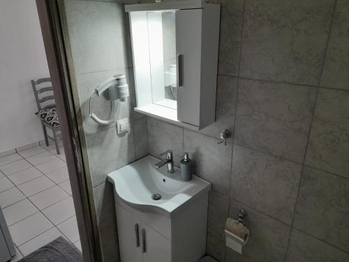 a bathroom with a sink and a mirror at Silver view in Batsi