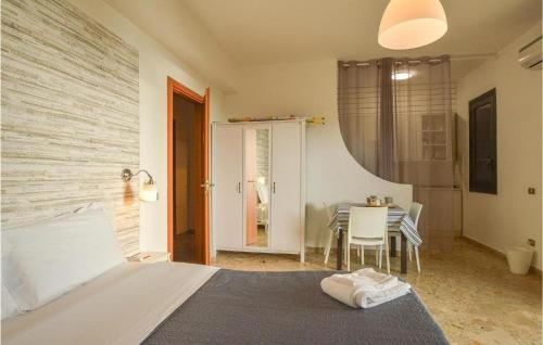 a bedroom with a bed and a table with chairs at Bahari Beachfront Aparthotel Selinunte in Marinella di Selinunte