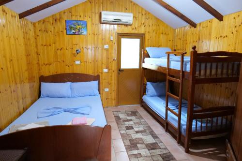 una habitación con dos literas y una silla en GuestHouse Hamiti Llogara, en Vlorë