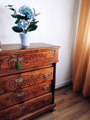 a wooden dresser with a vase of blue flowers on it at El Rincón del Alma Mía in Simancas