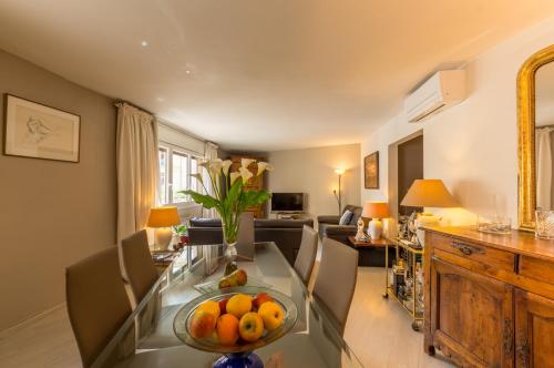 un salon avec une table avec un bol de fruits dessus dans l'établissement Jardin de la reine - Premiere conciergerie, à Montpellier