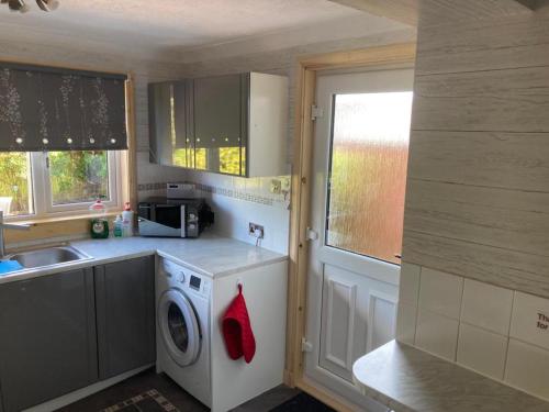 a kitchen with a washing machine and a sink at 3bedroom 1bathroom 1 shower room in quiet area in Inverness
