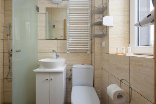 a bathroom with a white toilet and a sink at Willa Szamotulanka - Pokoje Wakacyjne Rewal - Plac Zabaw & Grill - by Noclegi Renters in Rewal