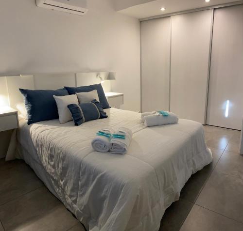 1 dormitorio con 1 cama grande y toallas. en Suites Quality 2 - Rosario en Rosario