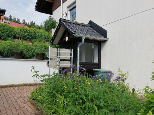 a garden with purple flowers in front of a house at Ferienglück Unterkirnach in Unterkirnach