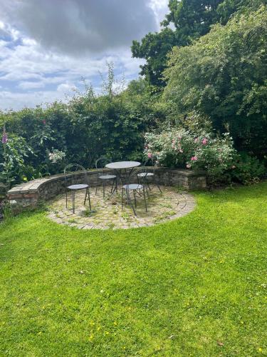 a table and chairs sitting on a circle in the grass at Swallow Cottage at Duffryn Mawr Cottages in Hensol