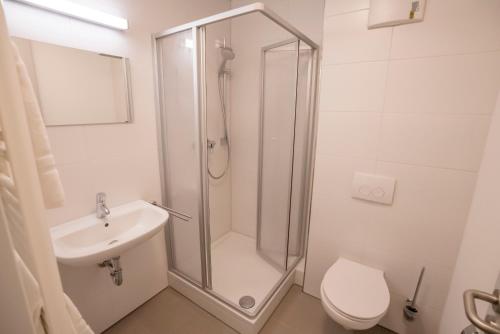 ein Bad mit einer Dusche, einem WC und einem Waschbecken in der Unterkunft SITE.INN Denkendorf in Denkendorf