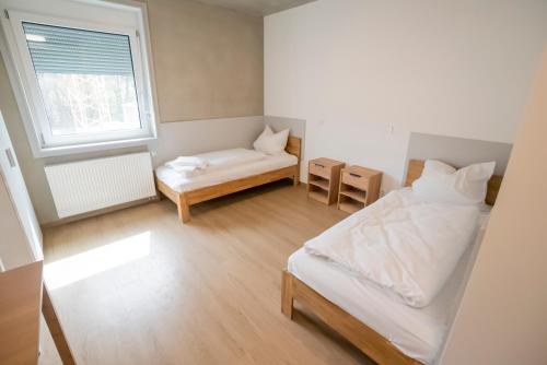 ein kleines Schlafzimmer mit einem Bett und einem Fenster in der Unterkunft SITE.INN Denkendorf in Denkendorf