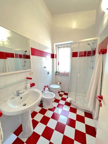 a red and white bathroom with a sink and a toilet at Veranda sul Paradiso in Costa Paradiso