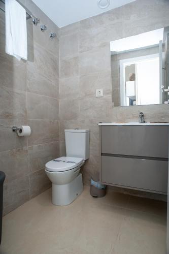 a bathroom with a toilet and a sink and a mirror at Holiday Deluxe Apartment Miramar Magic World in Oropesa del Mar