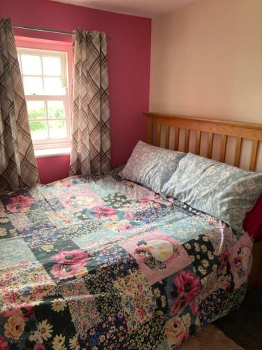 a bedroom with a quilt on a bed with a window at Charming 1-Bed Studio in Middlesbrough in Middlesbrough