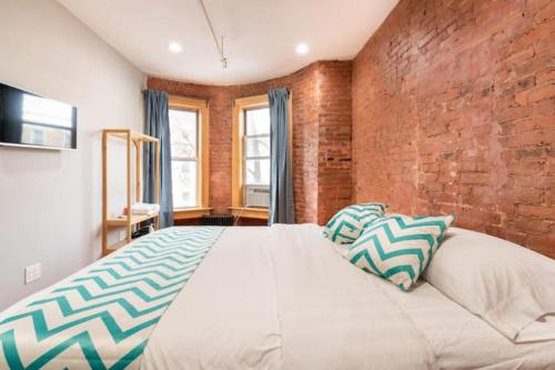 a bedroom with a large bed with a brick wall at Morris Guest House in Bronx