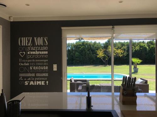 une salle à manger avec vue sur la piscine dans l'établissement Villa Alpilles, à Mouriès