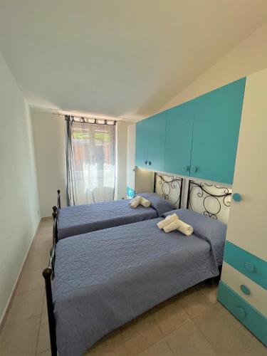 two beds in a bedroom with blue walls at Veranda sul Paradiso in Costa Paradiso