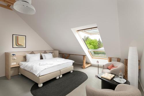 1 dormitorio con 1 cama, 1 silla y 1 ventana en Buborék en Csopak