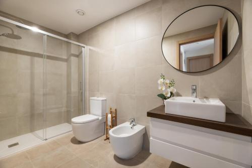a bathroom with a toilet and a sink and a mirror at VIGO THE HOME in Vigo