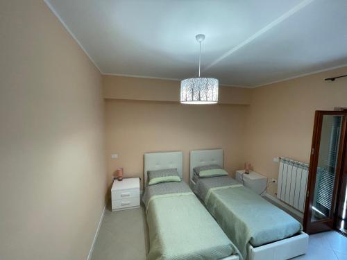 a bedroom with two beds and a chandelier at Residenza Punta Acquabella in Ortona