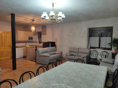 ein Wohnzimmer mit Tisch und Stühlen und eine Küche in der Unterkunft Casa Rural Baños del Rey con piscina climatizada in Vega de Santa María