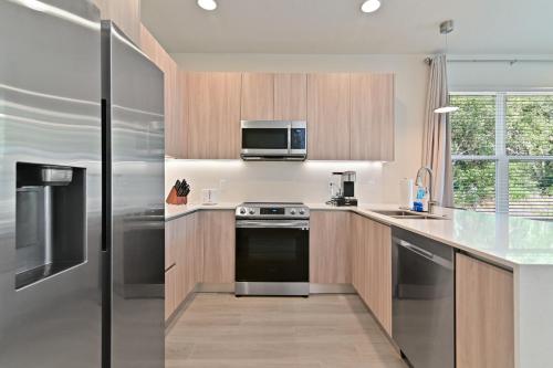a kitchen with stainless steel appliances and a microwave at New Spacious & Tranquil Townhouse near Disney - 4BR, 3FB, and Pool in Orlando