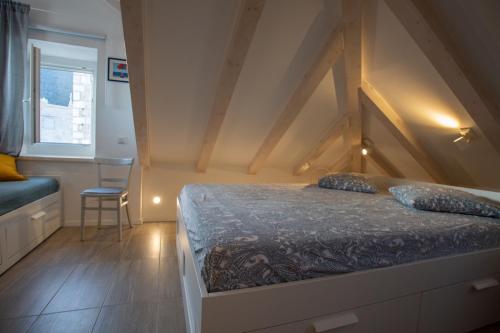 1 dormitorio con 1 cama y 1 silla en Sea Pearl en Komiža