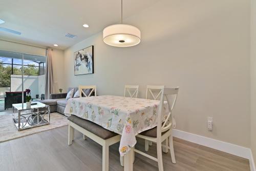 a living room with a table and chairs and a couch at New Spacious & Tranquil Townhouse near Disney - 4BR, 3FB, and Pool in Orlando