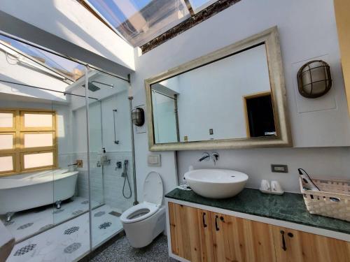 a bathroom with a sink and a toilet and a mirror at 阡陌-錦町民宿 in Tainan